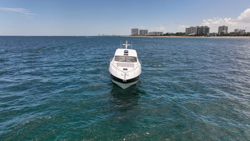 Arbitrage Yacht Photos Pics Sunseeker Predator 57 yacht on open water, 2017 model, with coastal skyline in background.