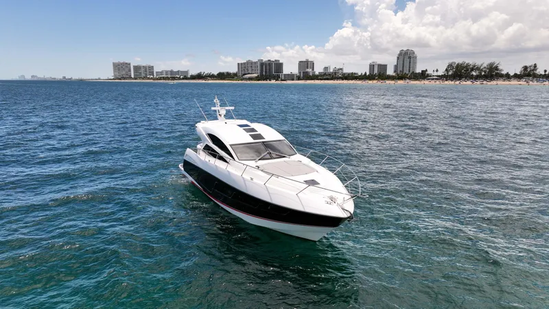 Arbitrage Yacht Photos Pics 2017 Sunseeker Predator 57 yacht cruising near a coastal city skyline.