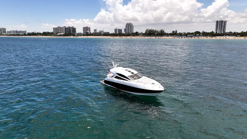 Arbitrage Yacht Photos Pics Sunseeker Predator 57 yacht on ocean near city skyline, 2017 model.