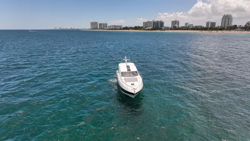 Arbitrage Yacht Photos Pics Sunseeker Predator 57 yacht cruising near a coastal city skyline, 2017 model.