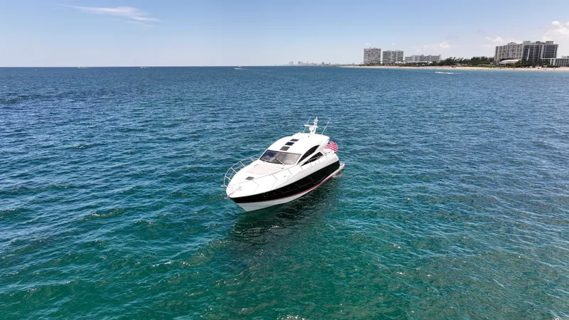 Arbitrage Yacht Photos Pics 2017 Sunseeker Predator 57 yacht on open sea near coastline, clear sky.
