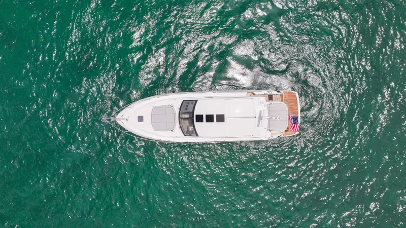Arbitrage Yacht Photos Pics Aerial view of 2017 Sunseeker Predator 57 yacht on turquoise water.