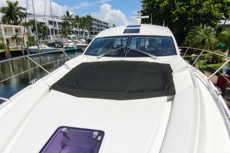 Arbitrage Yacht Photos Pics 2017 Sunseeker Predator 57 yacht docked near waterfront buildings and palm trees.