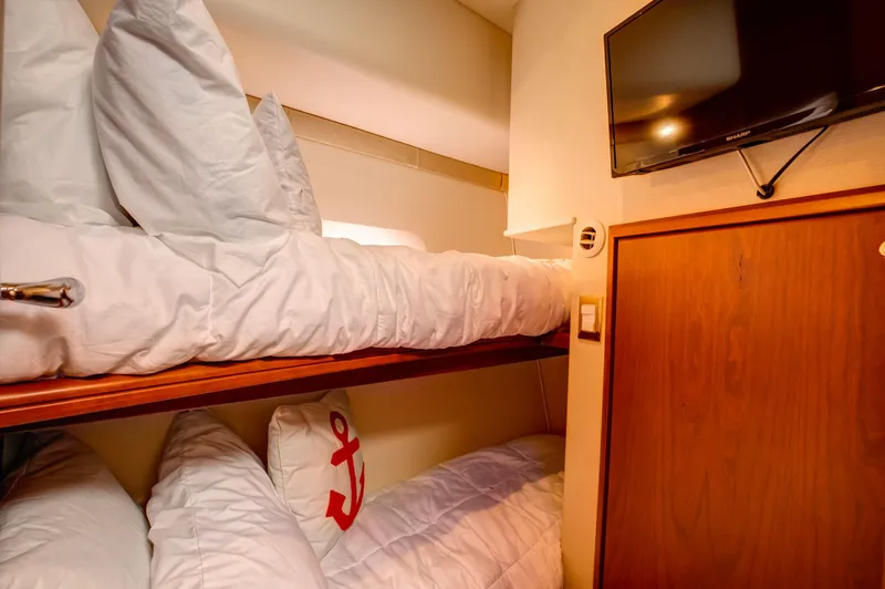  Yacht Photos Pics Bunk beds in 2006 Silverton 50 Convertible yacht cabin with TV and anchor-themed pillow.