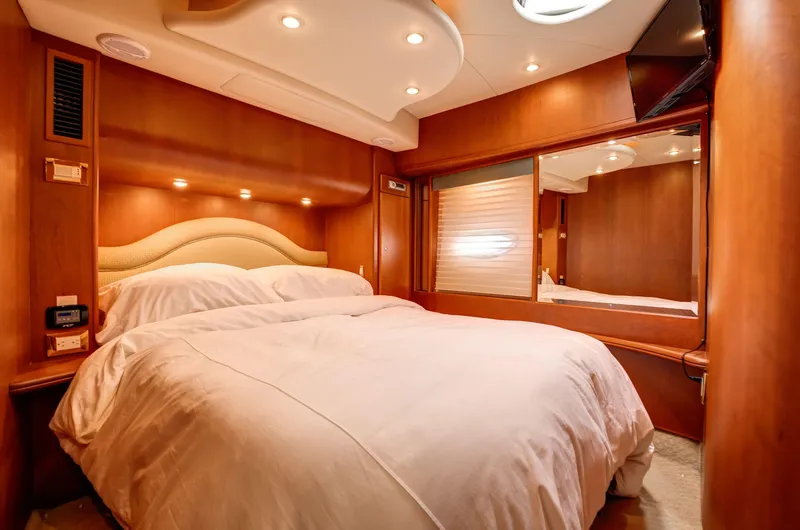  Yacht Photos Pics Luxurious bedroom interior of 2006 Silverton 50 Convertible yacht with elegant wood finishes.