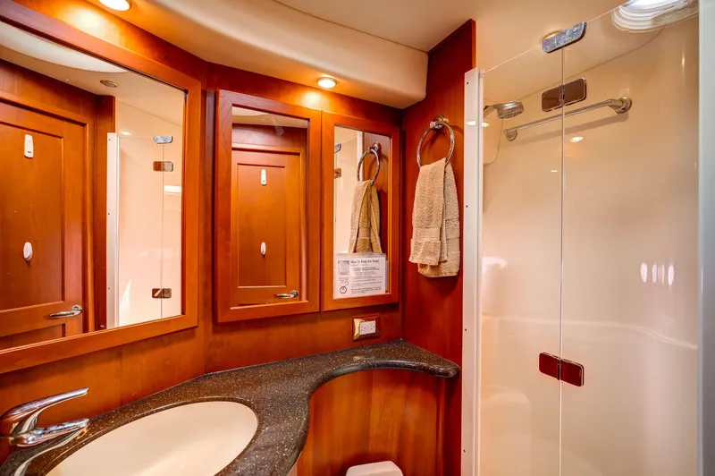  Yacht Photos Pics Luxurious bathroom in 2006 Silverton 50 Convertible yacht with wood cabinetry and modern fixtures.