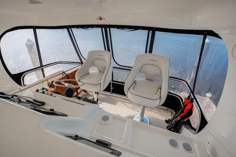  Yacht Photos Pics 2006 Silverton 50 Convertible yacht helm with two white captain chairs and panoramic windows.