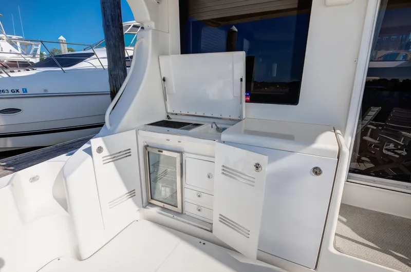  Yacht Photos Pics Outdoor kitchenette on a 2006 Silverton 50 Convertible yacht with storage and mini-fridge.