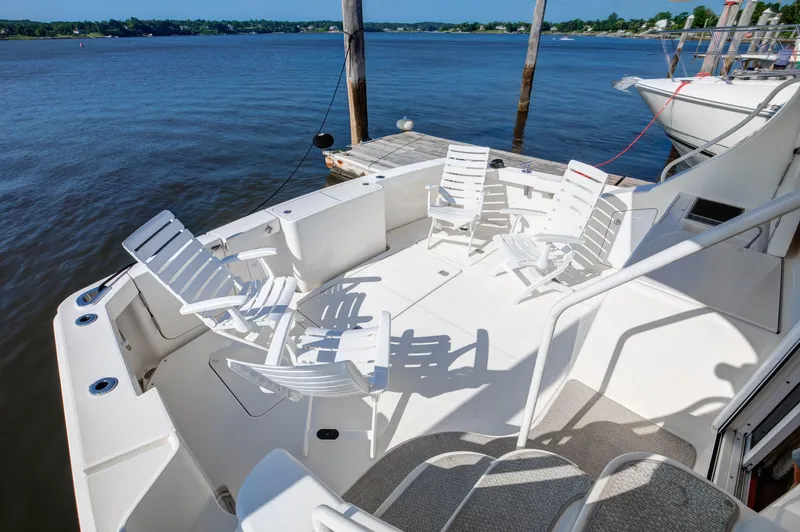  Yacht Photos Pics 2006 Silverton 50 Convertible yacht deck with white chairs overlooking serene water.