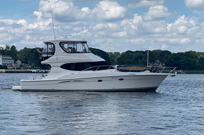  Yacht Photos Pics 2006 Silverton 50 Convertible yacht cruising on a calm lake under a cloudy sky.