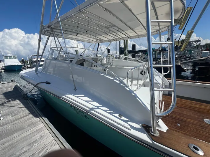  Yacht Photos Pics 1997 Strike 42 boat docked, featuring sleek design and spacious deck under a canopy.