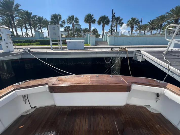  Yacht Photos Pics Stern view of 1997 Strike 42 boat docked, with wooden deck and palm trees in background.