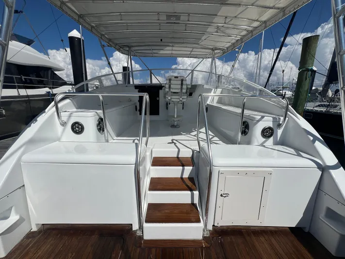  Yacht Photos Pics 1997 Strike 42 boat deck with seating, wooden steps, and canopy in a marina setting.