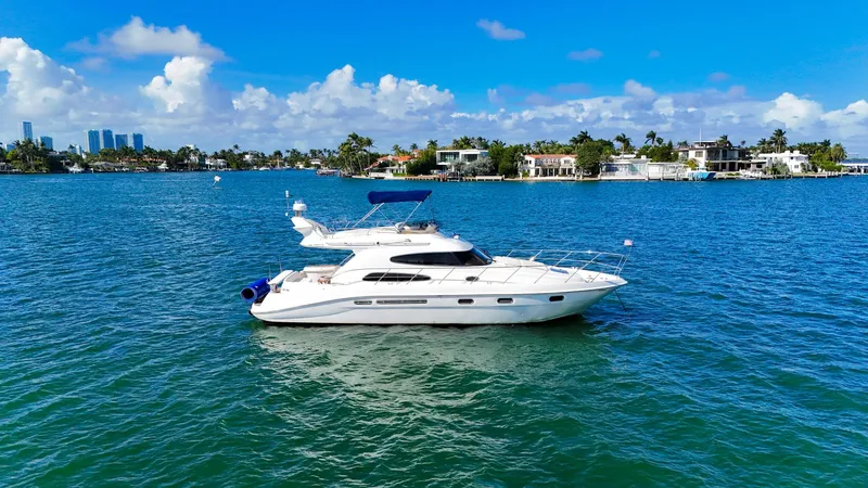 Seafari Yacht Photos Pics 2004 Sealine 47 yacht on blue water, clear sky, coastal background.