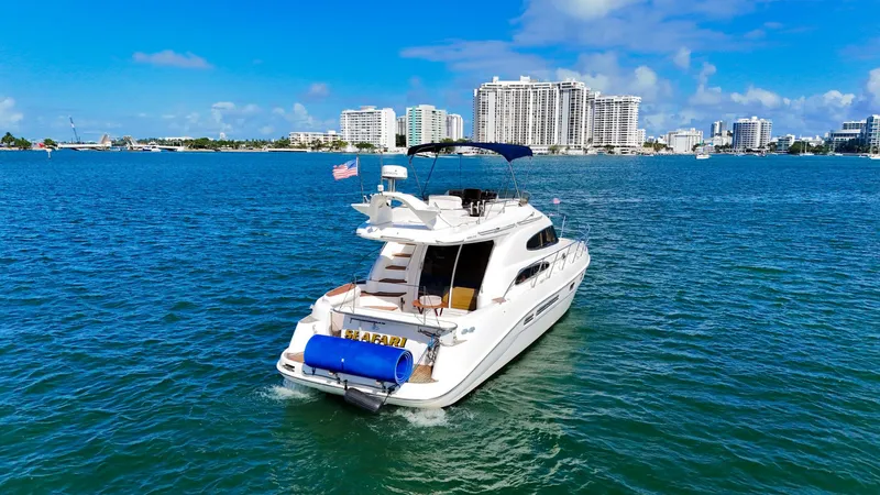 Seafari Yacht Photos Pics 2004 Sealine 47 yacht cruising in sunny waters near city skyline.