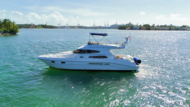 Seafari Yacht Photos Pics 2004 Sealine 47 yacht cruising on a sunny, scenic waterway.