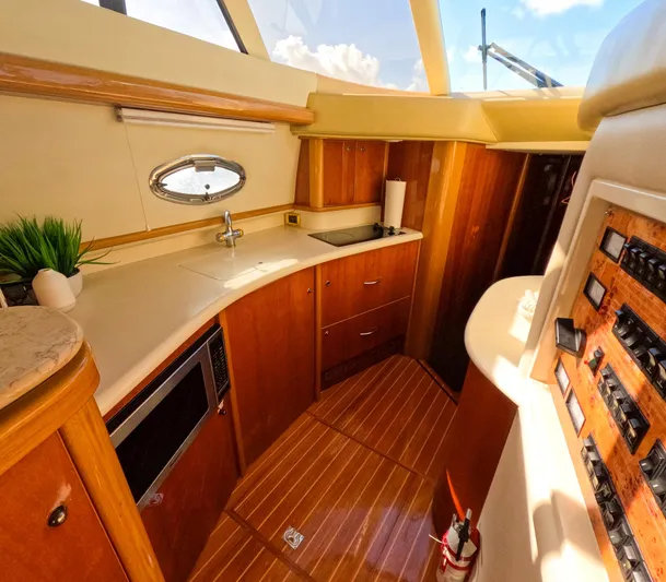Seafari Yacht Photos Pics Luxurious 2004 Sealine 47 yacht interior with modern kitchen and wooden cabinetry.