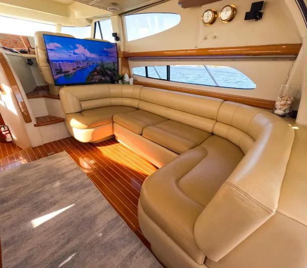 Seafari Yacht Photos Pics Luxurious 2004 Sealine 47 yacht interior with leather seating, wood flooring, and large TV.
