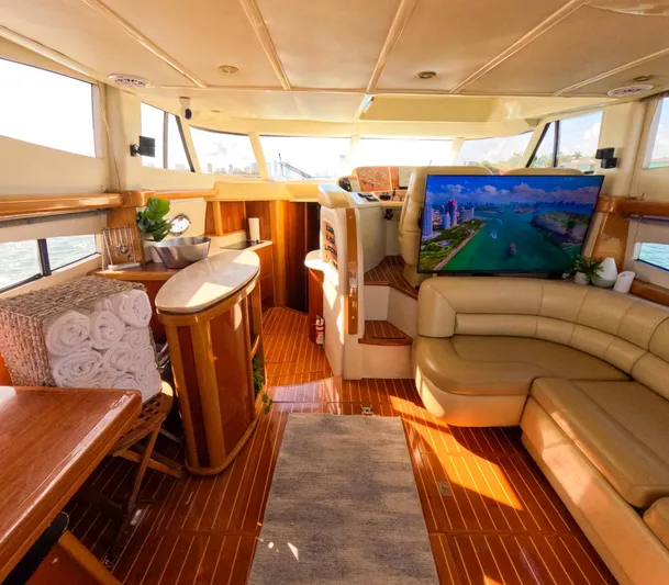 Seafari Yacht Photos Pics Luxurious 2004 Sealine 47 yacht interior with leather seating, wood accents, and large TV.