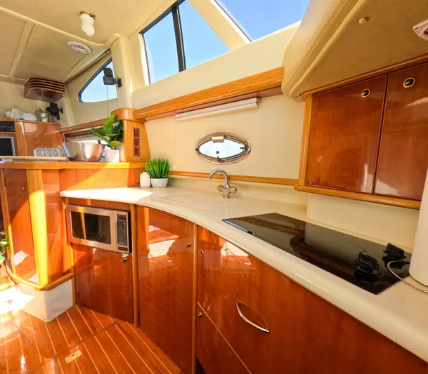 Seafari Yacht Photos Pics Luxurious 2004 Sealine 47 yacht kitchen with modern appliances and elegant wood finish.