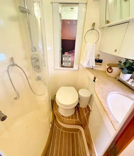 Seafari Yacht Photos Pics 2004 Sealine 47 yacht bathroom with shower, toilet, sink, and wooden flooring.