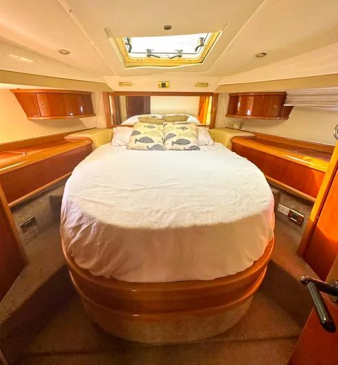 Seafari Yacht Photos Pics Luxurious cabin interior of a 2004 Sealine 47 yacht with a cozy bed and wooden accents.