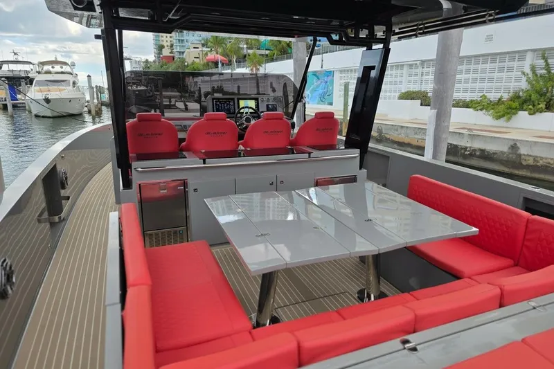 Never Enough Yacht Photos Pics 2023 De Antonio Yachts D42 Open with red seating and sleek design at a marina.
