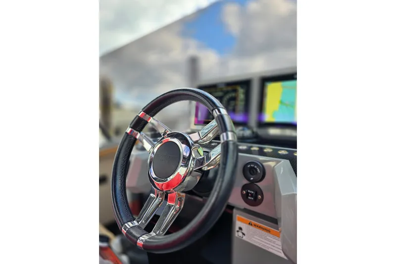 Never Enough Yacht Photos Pics Steering wheel of 2023 De Antonio Yachts D42 Open with navigation screens in background.