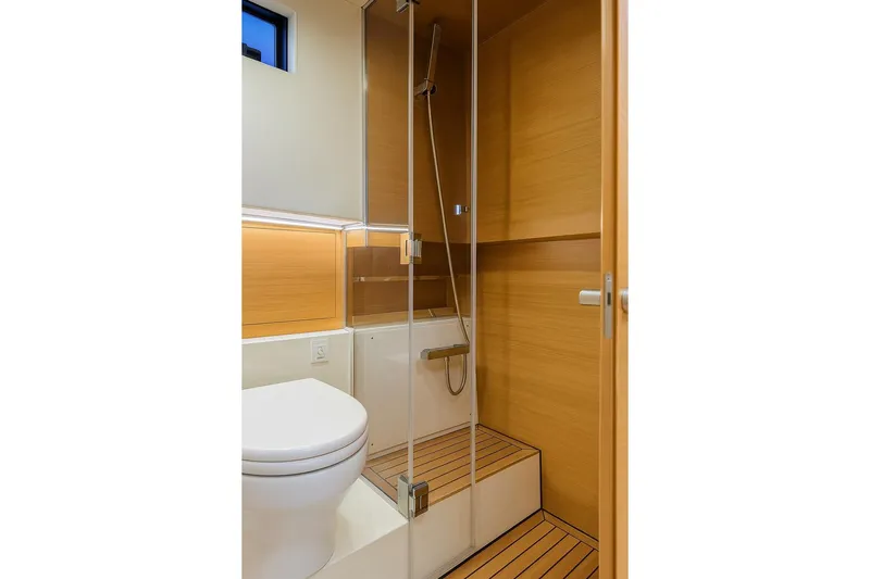 Never Enough Yacht Photos Pics Modern bathroom in 2023 De Antonio Yachts D42 Open, featuring sleek wood paneling and glass shower.