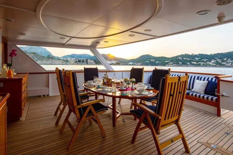  Yacht Photos Pics Luxurious dining setup on 1982 Feadship Classic yacht with scenic ocean view.