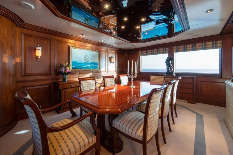  Yacht Photos Pics Luxurious dining room on 1982 Feadship Classic yacht with elegant wood paneling and ocean view.