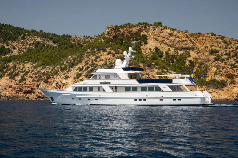  Yacht Photos Pics Luxury 1982 Feadship Classic yacht cruising near rocky coastline.