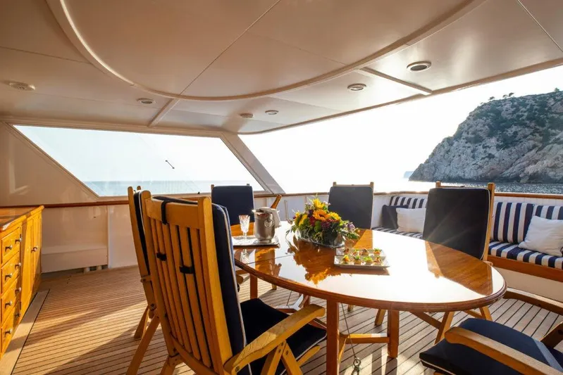  Yacht Photos Pics Luxurious 1982 Feadship Classic yacht deck with elegant dining setup and scenic ocean view.
