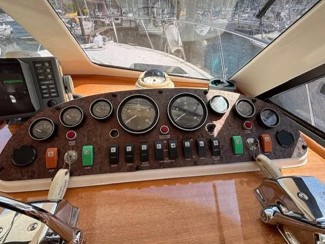 Island Dreamer Yacht Photos Pics 1999 Riviera Convertible yacht dashboard with gauges and controls in a marina setting.