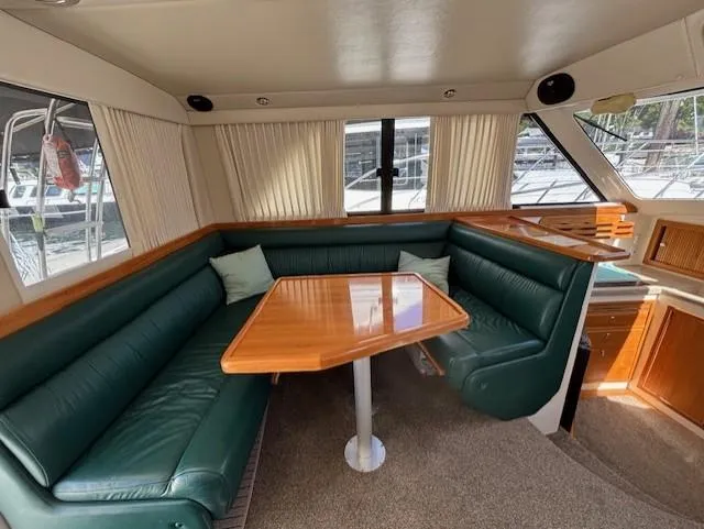 Island Dreamer Yacht Photos Pics 1999 Riviera Convertible yacht interior with green leather seating and wooden table.