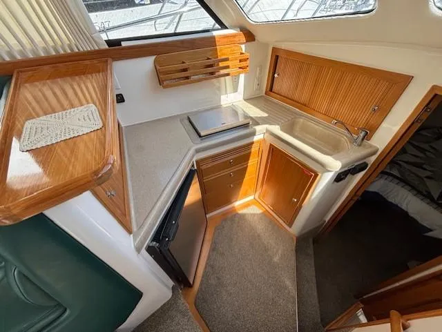 Island Dreamer Yacht Photos Pics 1999 Riviera Convertible kitchen with wooden cabinets, sink, and compact design.