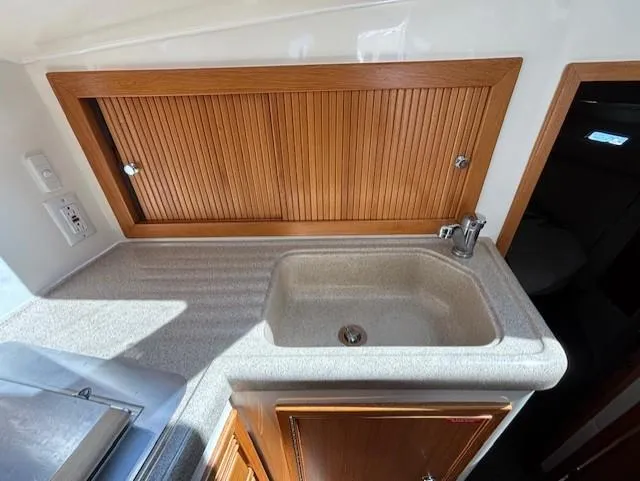 Island Dreamer Yacht Photos Pics 1999 Riviera Convertible kitchen sink with wooden cabinets and countertop.