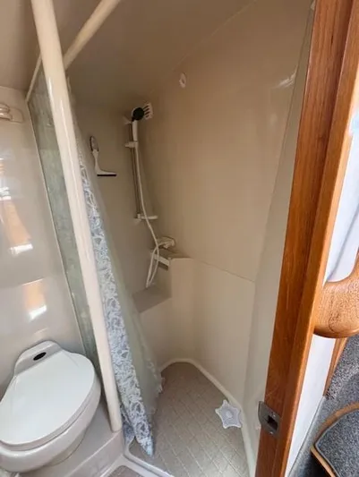 Island Dreamer Yacht Photos Pics 1999 Riviera Convertible bathroom with shower and toilet, compact and functional design.