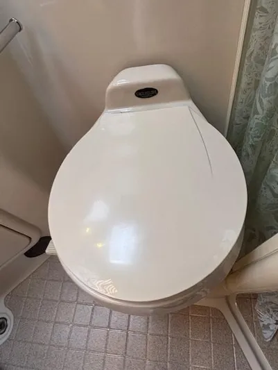 Island Dreamer Yacht Photos Pics 1999 Riviera Convertible bathroom with closed toilet lid and tiled floor.