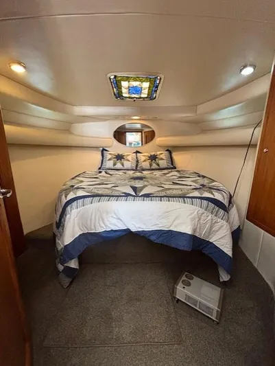 Island Dreamer Yacht Photos Pics 1999 Riviera Convertible cabin with cozy bed, decorative ceiling, and ambient lighting.