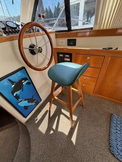 Island Dreamer Yacht Photos Pics 1999 Riviera Convertible boat interior with wooden helm, blue stool, and orca artwork.