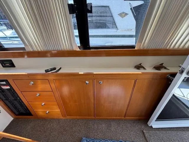 Island Dreamer Yacht Photos Pics 1999 Riviera Convertible interior with wooden cabinets and drawers, featuring a window view.