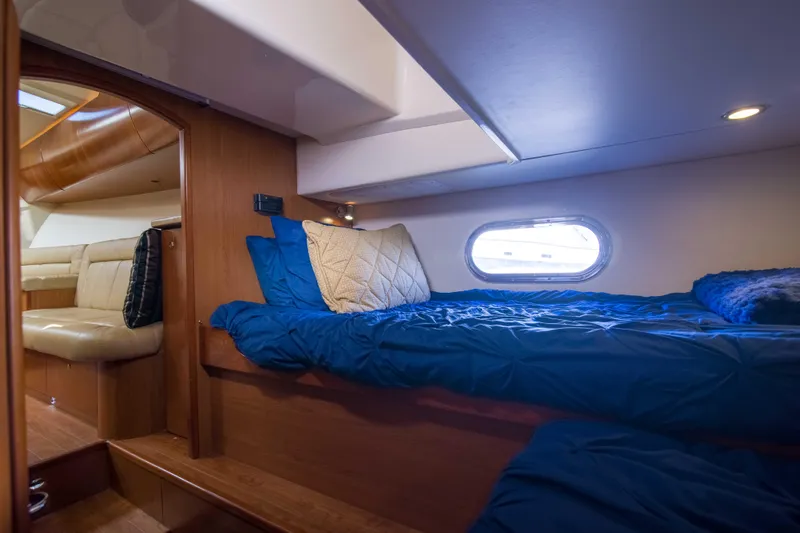 Date Night Keeping It Reel Yacht Photos Pics 2010 Luhrs Canyon Express cabin interior with cozy bedding and porthole window.