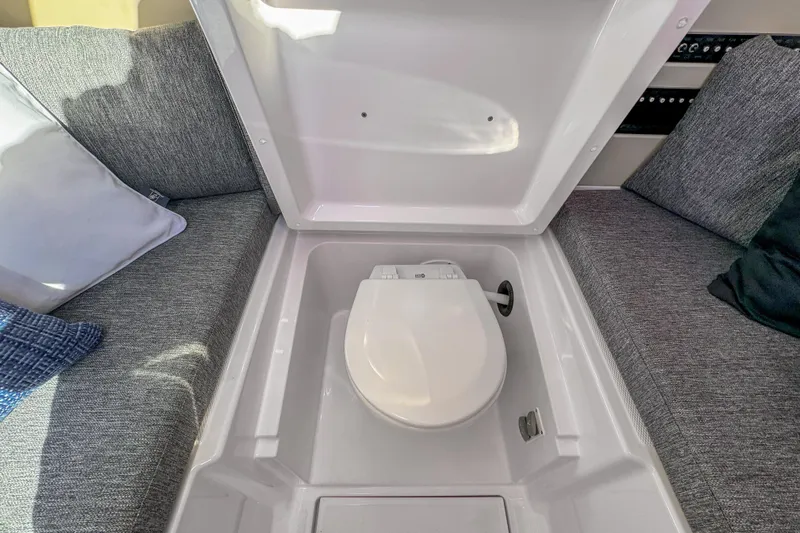  Yacht Photos Pics Hidden toilet compartment on 2026 Axopar 29 Sun Top boat, surrounded by gray seating.