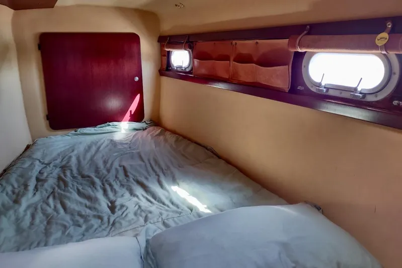 Nyango Yacht Photos Pics Cabin interior of 1996 Fountaine Pajot Venezia 42 catamaran with bed and porthole windows.