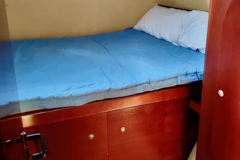 Nyango Yacht Photos Pics Cozy cabin bed with blue bedding in 1996 Fountaine Pajot Venezia 42 yacht.