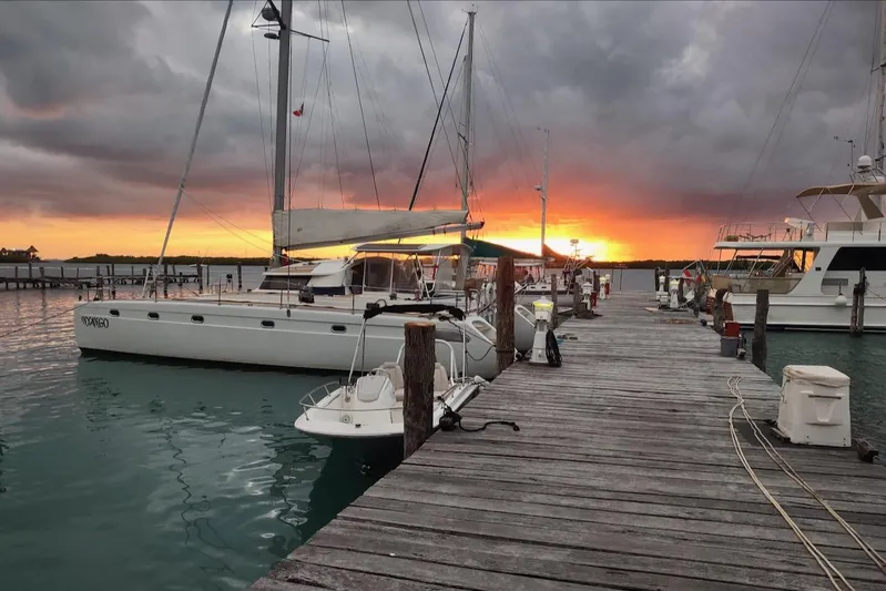 Nyango Yacht Photos Pics 1996 Fountaine Pajot Venezia 42 catamaran docked at sunset with dramatic sky.