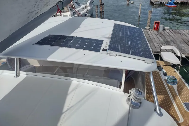 Nyango Yacht Photos Pics 1996 Fountaine Pajot Venezia 42 catamaran with solar panels docked at a marina.