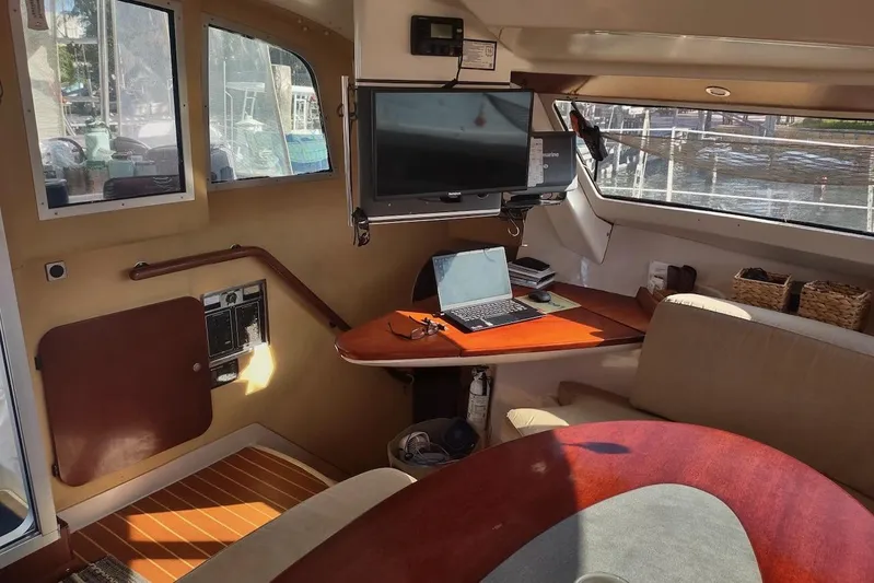 Nyango Yacht Photos Pics Interior of 1996 Fountaine Pajot Venezia 42 catamaran with laptop and TV setup.