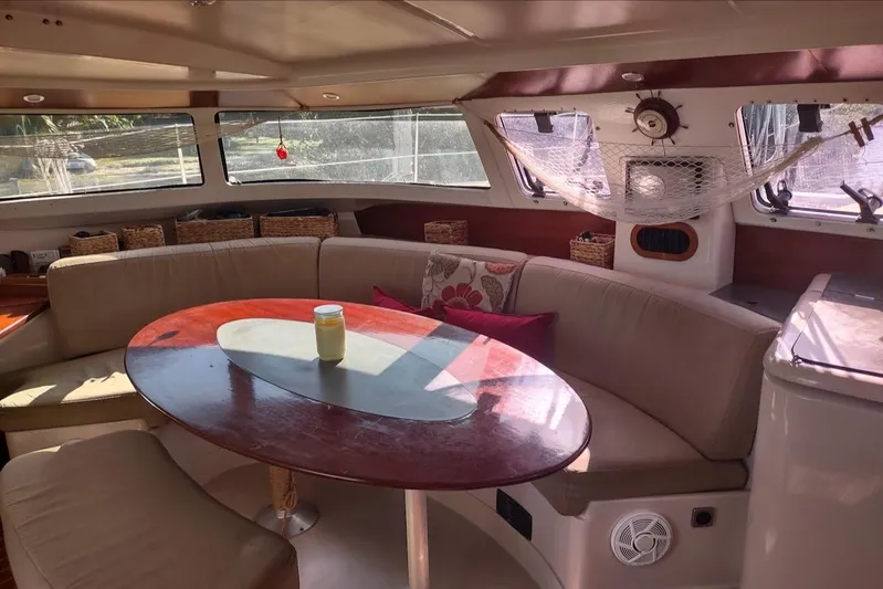 Nyango Yacht Photos Pics Interior of 1996 Fountaine Pajot Venezia 42 catamaran with cozy seating and table.